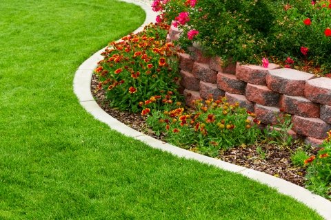 Tiered Garden Bed With Flowers And Shrubs And A Manicured Lawn