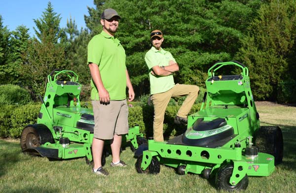 Local Landscaping Company Team Members With Quite Electric Mowers In Nice Landscape