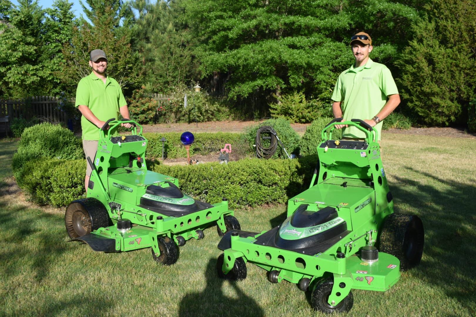 Local Landscaping Company Team Members With Quite Electric Mowers In Nice Landscape