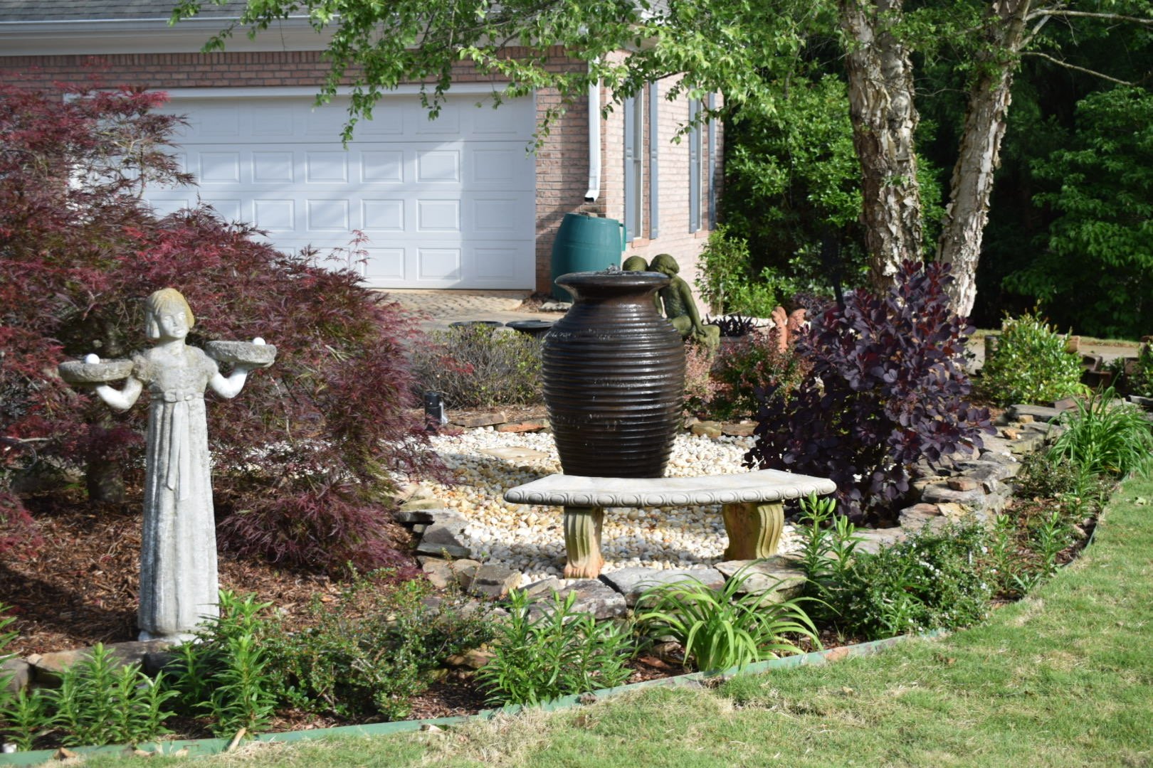 Custom Designed Landscaping With Garen Beds, Shrubs, And Statues